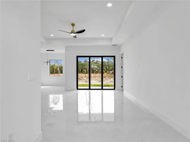 Unfurnished room with a ceiling fan, a tray ceiling, and recessed lighting