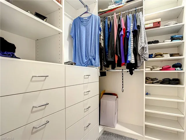 Spacious closet with built-in shelving and drawers