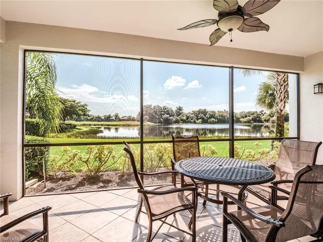 Sunroom / solarium featuring ceiling fan and a water view