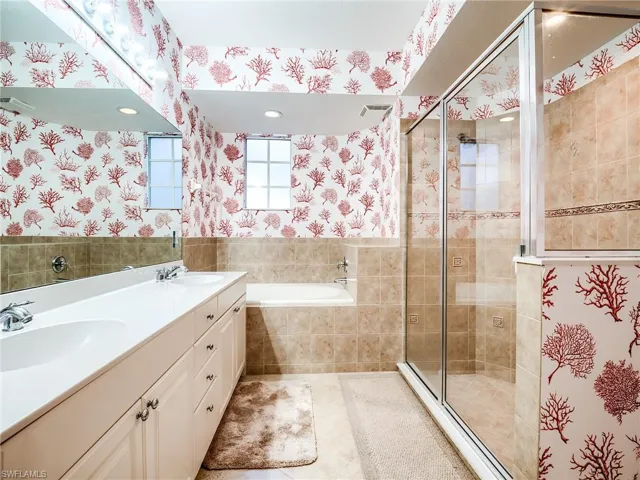 Bathroom with tile patterned flooring, plus walk in shower, and double sink vanity
