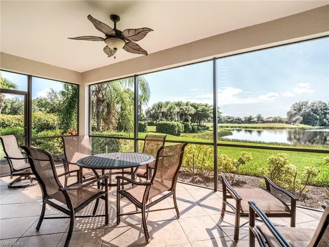 Sunroom / solarium featuring ceiling fan and a water view