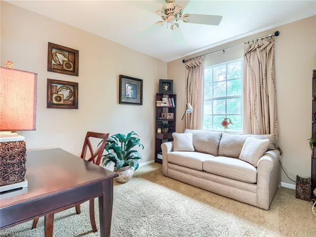 Office with carpet floors and ceiling fan