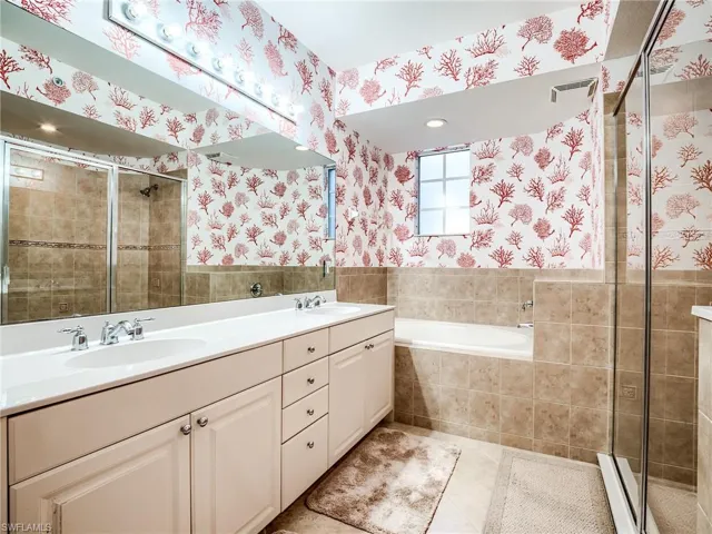 Bathroom with tile patterned flooring, plus walk in shower, and dual vanity
