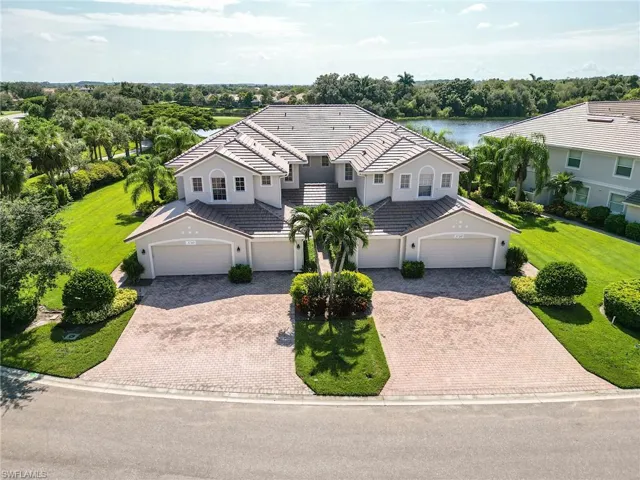 View of front of house featuring a water view, a garage, and a front lawn