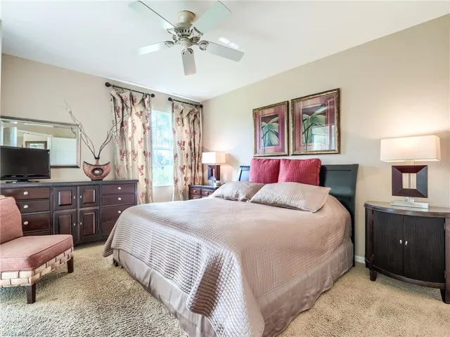 Carpeted bedroom featuring ceiling fan