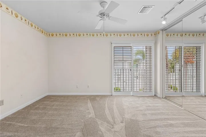 Carpeted spare room with ceiling fan and rail lighting