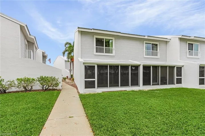 Rear view of property featuring a yard and a sunroom