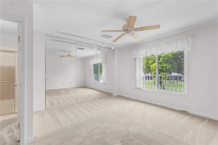 Carpeted empty room featuring ceiling fan