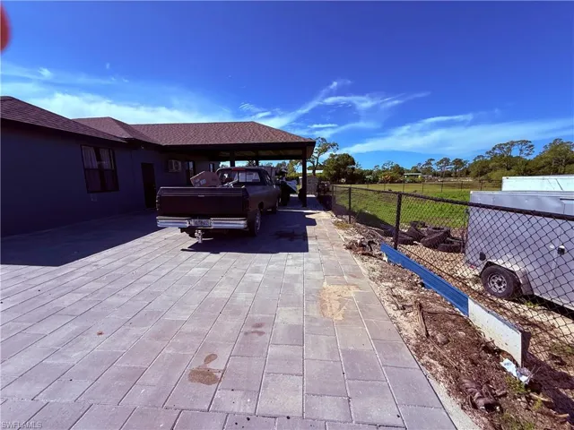 Expansive paver driveway extending to a covered carport