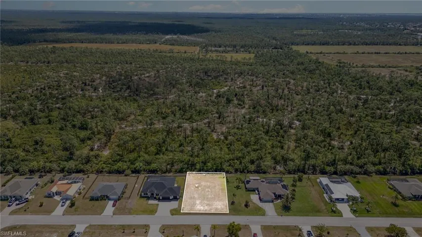 Birds eye view of property featuring a wooded view