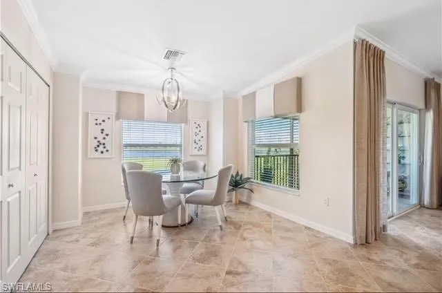 Dining area with crown molding, healthy amount of natural light, and a chandelier