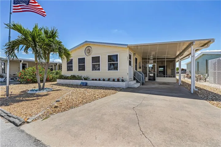 Manufactured / mobile home with entry steps, a sunroom, a carport, and concrete driveway