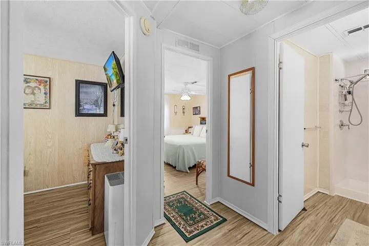Hall featuring crown molding, light wood finished floors, baseboards, and visible vents