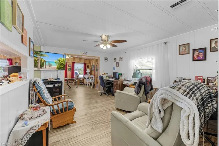 Living room with wood finished floors, ceiling fan, and visible vents