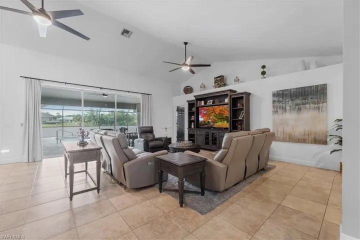 Living area featuring visible vents, a ceiling fan, high vaulted ceiling, and light tile patterned floors