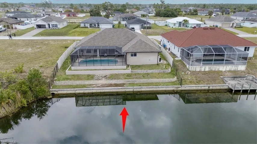 Birds eye view of property with a water view and a residential view