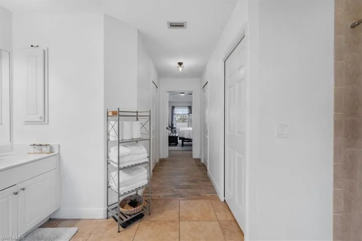 Hallway with light tile patterned flooring and visible vents