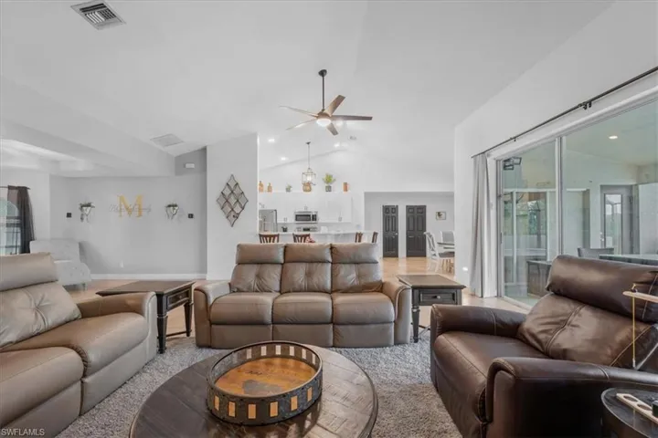 Living room with recessed lighting, lofted ceiling, visible vents, and ceiling fan
