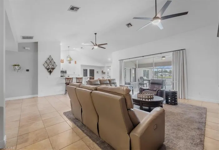 Living room with visible vents, a ceiling fan, and light tile patterned floors