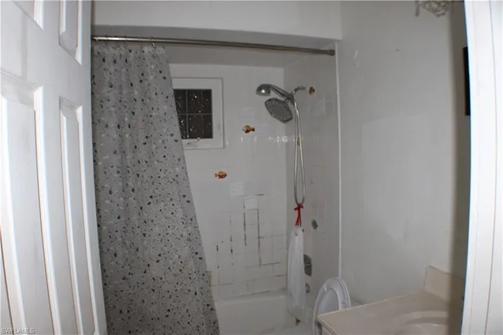 Full bathroom featuring vanity, toilet, and shower / bathtub combination with curtain