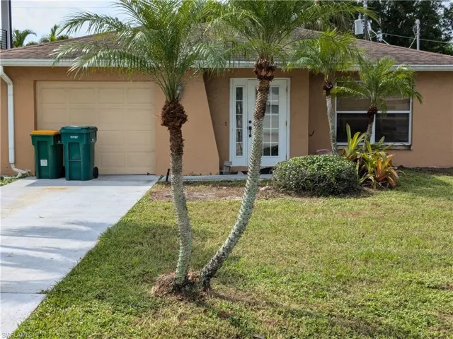 Ranch-style home with a garage and a front lawn
