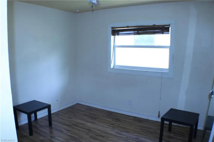 Spare room featuring dark wood-type flooring