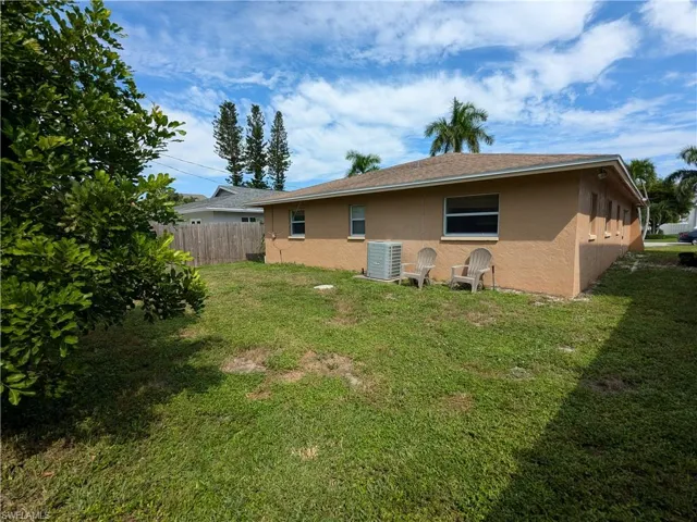 Back of property featuring a yard and cooling unit