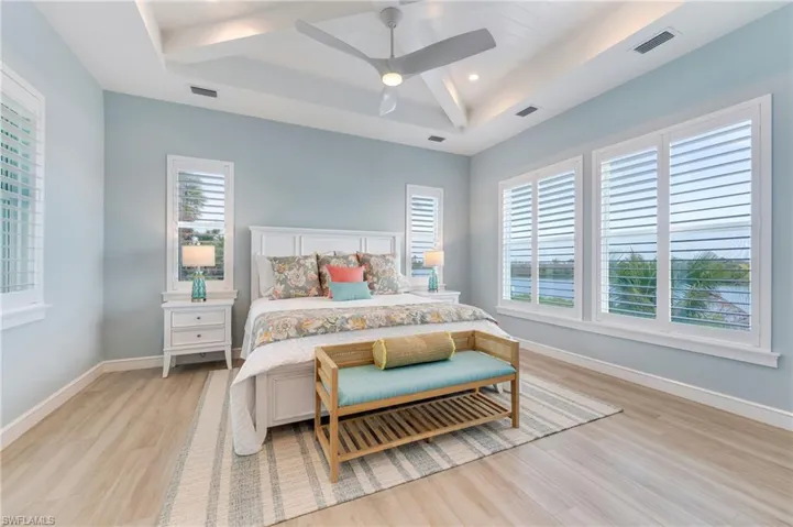 Bedroom with a ceiling fan, light wood-style flooring, recessed lighting, and a raised ceiling