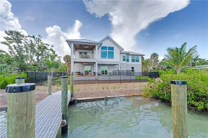 Dock area featuring a balcony, a patio, and a water view