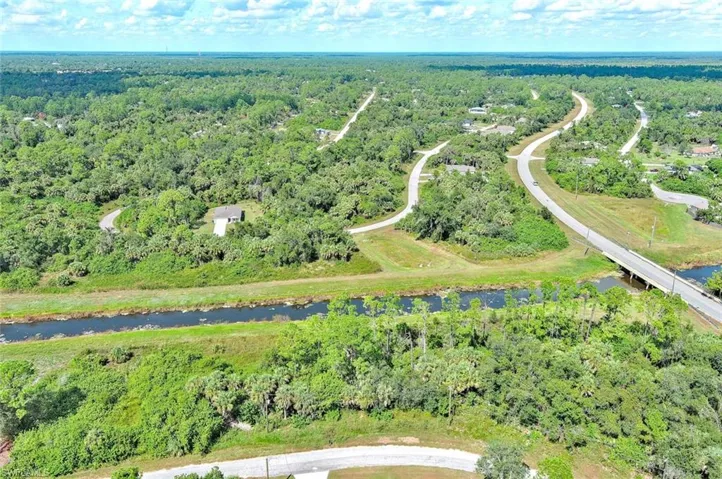 Bird's eye view of a heavily wooded area and a nearby body of water