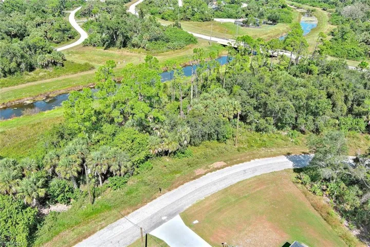 Aerial view of property's location with a large body of water and a tree filled landscape
