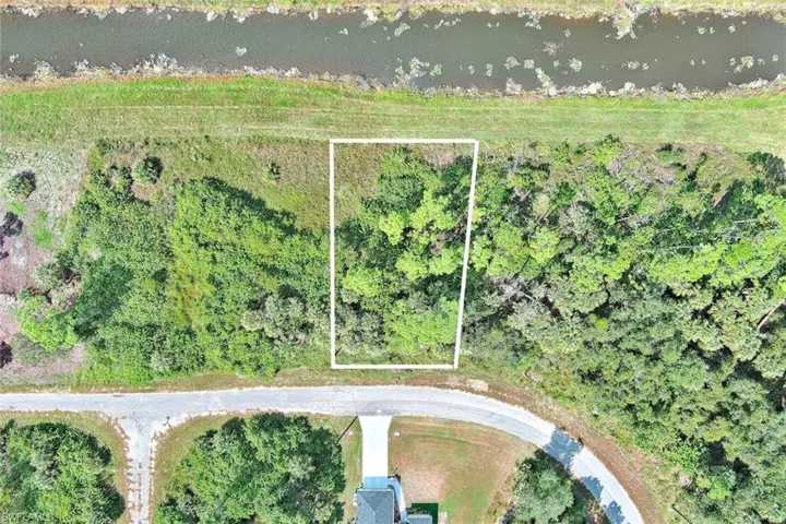 Aerial overview of property's location with property boundaries highlighted and a large body of water