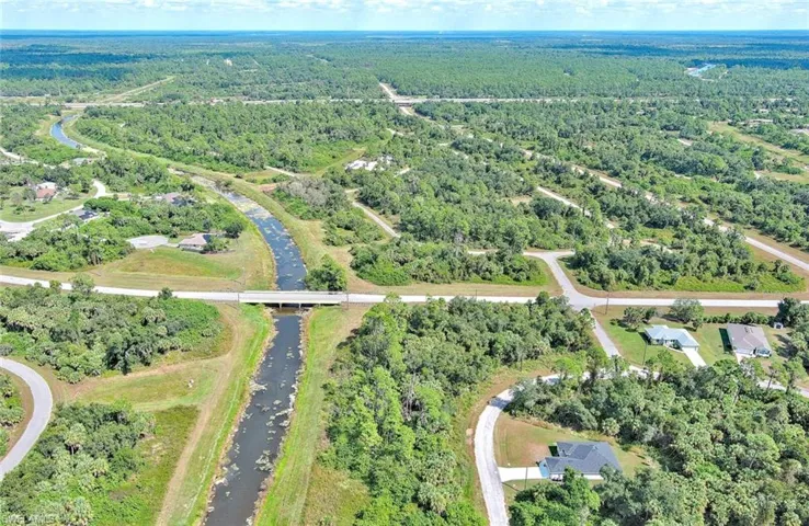 Aerial overview of property's location with a heavily wooded area