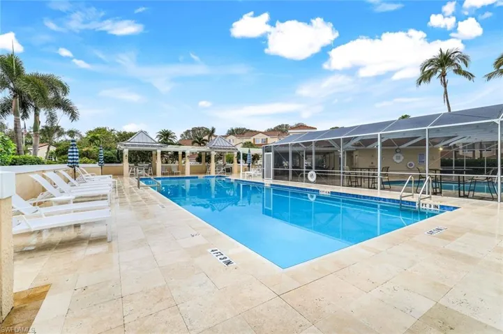 Community pool with a gazebo, a patio area, and glass enclosure