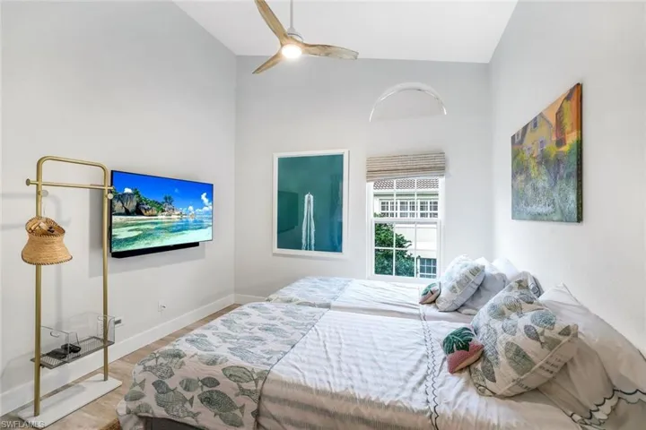 Bedroom featuring high vaulted ceiling, baseboards, ceiling fan, and light wood finished floors