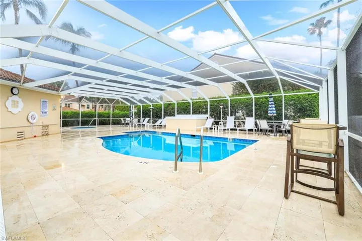 Community pool with a patio area and glass enclosure