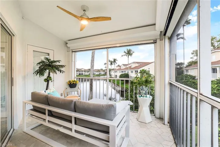 Balcony featuring a sunroom, ceiling fan, a residential view, a water view, and outdoor lounge area