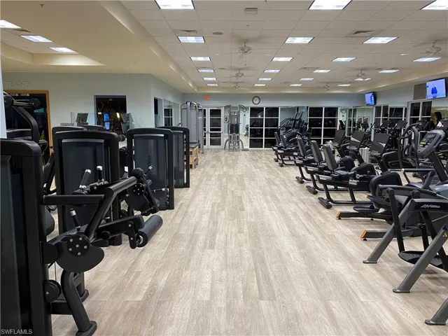Gym featuring light wood finished floors, visible vents, and a drop ceiling