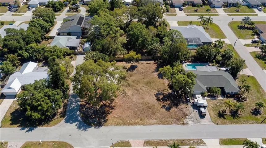 Aerial view of property and surrounding area with nearby suburban area