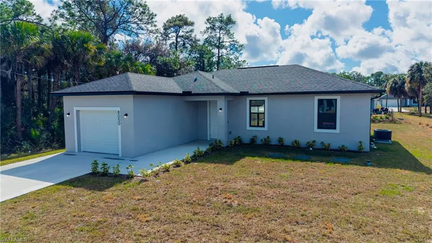 Single story home with a front yard, a garage, stucco siding, and roof with shingles