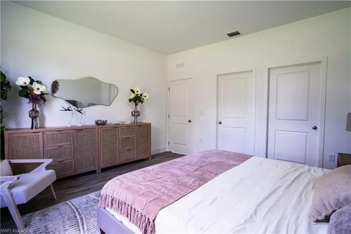 Bedroom with dark wood-style flooring and a closet