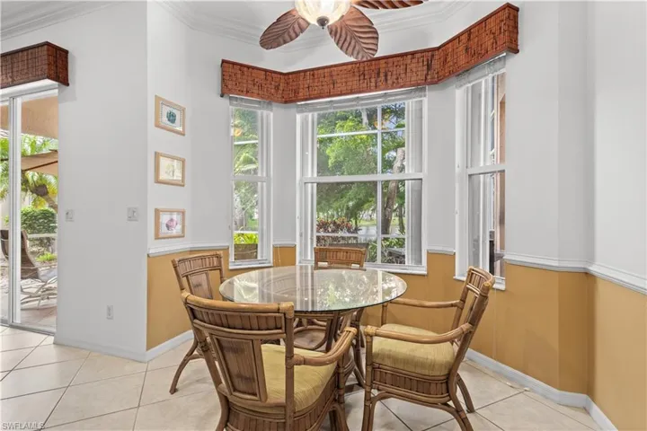 Living room featuring ceiling fan, crown molding, light tile patterned floors, healthy amount of natural light, and recessed lighting