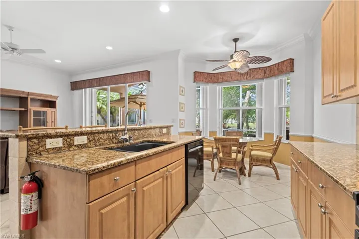 Florida Coastal home with stucco siding, a front yard, decorative driveway, a garage, and a tile roof