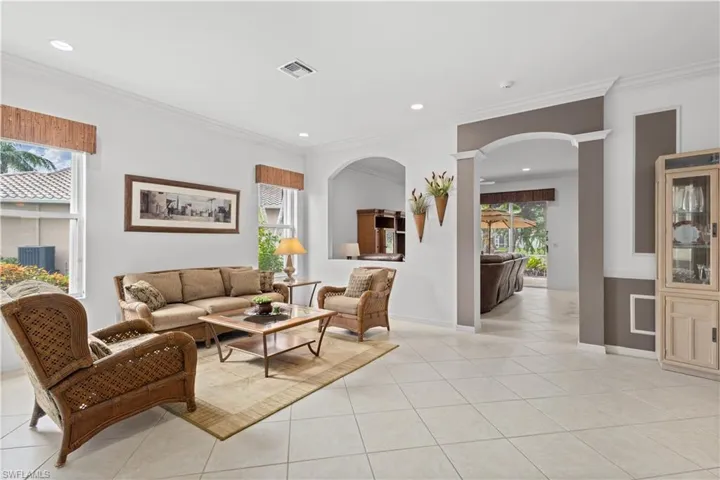 Living area with ornamental molding, recessed lighting, light tile patterned floors, and a sunroom
