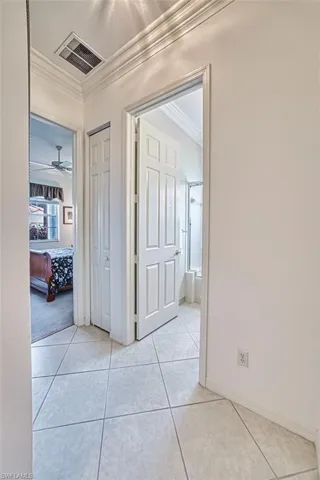 Hallway featuring light tile patterned floors and ornamental molding