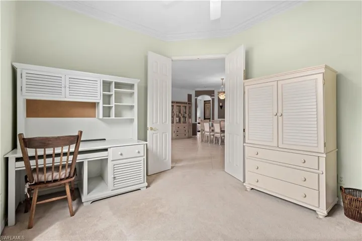 Living area featuring light tile patterned flooring, crown molding, recessed lighting, and arched walkways