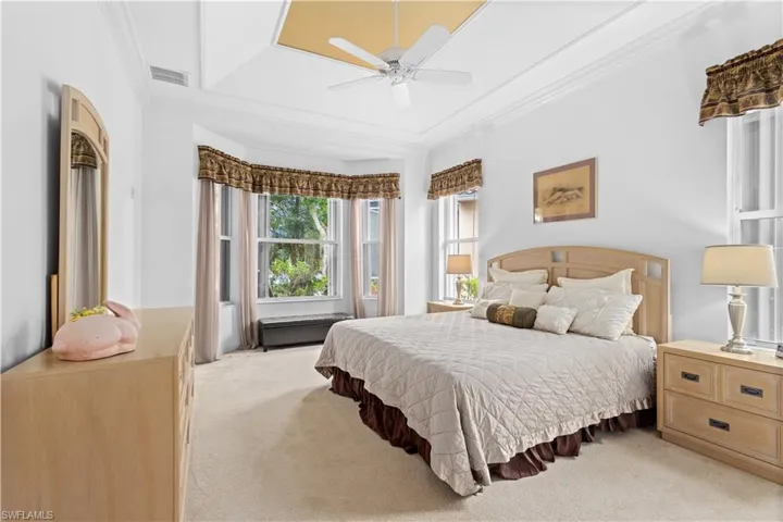 Bedroom with crown molding, light carpet, and ceiling fan