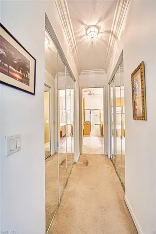 Corridor featuring ornamental molding, carpet floors, and a textured ceiling