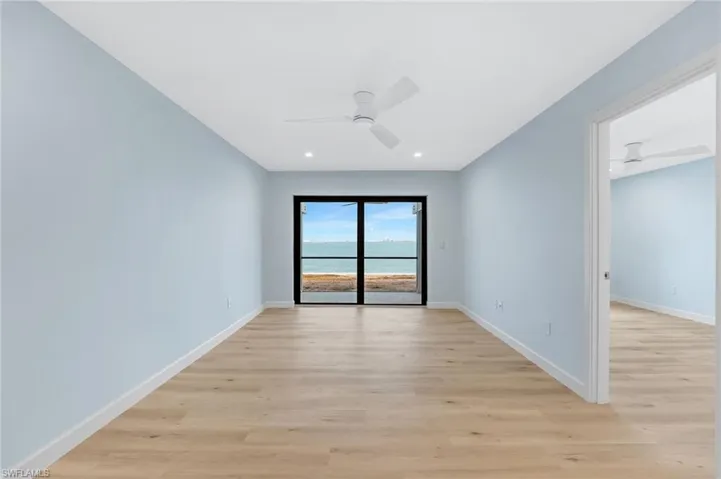 The living area is bright, coastal, and perfectly positioned to capture the waterfront setting.