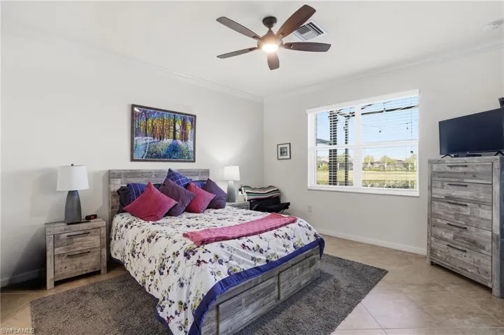 Bedroom featuring ornamental molding, a ceiling fan, and light tile patterned floors